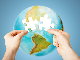 Image showing hands with white blank puzzle over earth globe