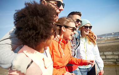 Image showing smiling friends in sunglasses laughing on street