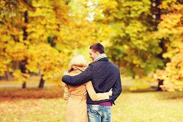 Image showing smiling couple hugging in autumn park from back