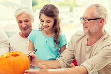 Image showing happy family sitting with pumpkins at home