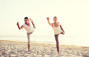 Image showing couple making yoga exercises outdoors