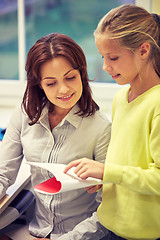 Image showing school girl with notebook and teacher in classroom