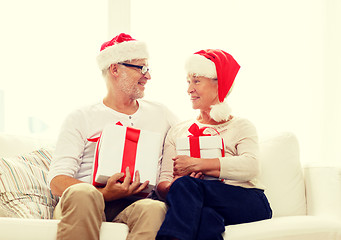 Image showing happy senior couple in santa hats with gift boxes