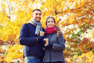 Image showing smiling couple with coffee cups in autumn park