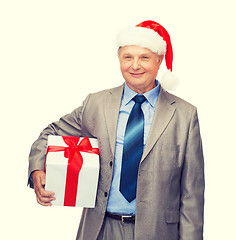 Image showing smiling man in suit and santa helper hat with gift