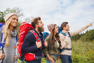 Image showing group of smiling friends with backpacks hiking