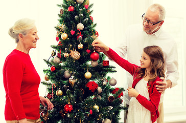 Image showing smiling family decorating christmas tree at home