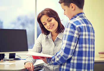 Image showing school boy with notebook and teacher in classroom