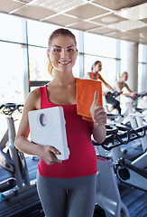 Image showing smiling woman with scales and towel in gym