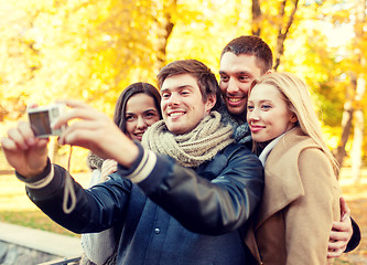 Image showing group of smiling men and women making selfie