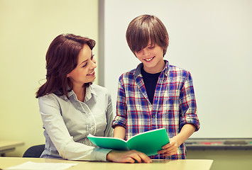 Image showing school boy with notebook and teacher in classroom