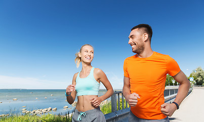 Image showing smiling couple running at summer seaside