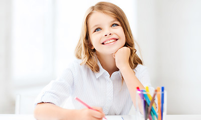 Image showing smiling little student girl drawing at school