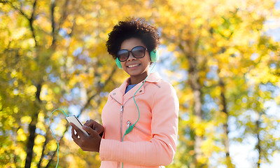 Image showing happy young woman with smartphone and headphones