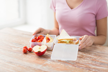 Image showing close up of woman with food in plastic container