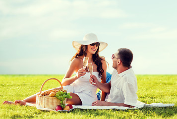 Image showing smiling couple drinking champagne on picnic