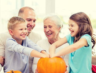 Image showing happy family sitting with pumpkins at home