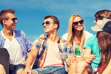 Image showing group of smiling friends sitting on city street