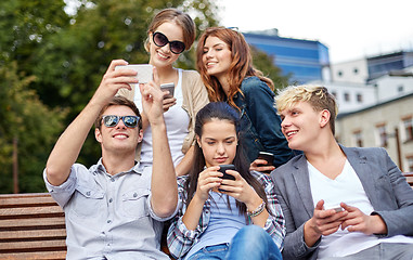 Image showing students or teenagers with smartphones at campus