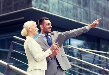 Image showing smiling businessmen with tablet pc outdoors