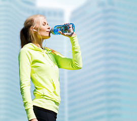 Image showing woman drinking water after doing sports outdoors