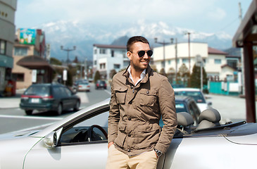 Image showing happy man near cabriolet car over city in japan