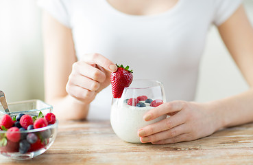 Image showing close up of woman hands with yogurt and berries