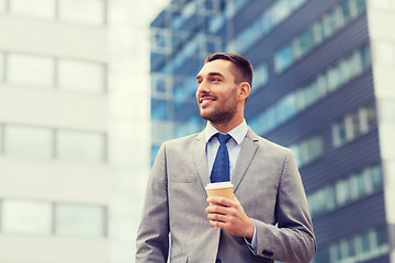 Image showing young smiling businessman with paper cup outdoors