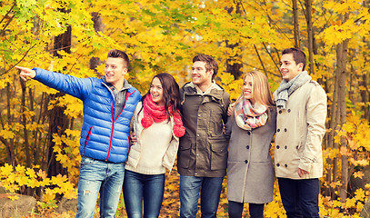 Image showing group of smiling men and women in autumn park