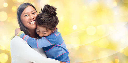 Image showing happy mother and daughter hugging over lights