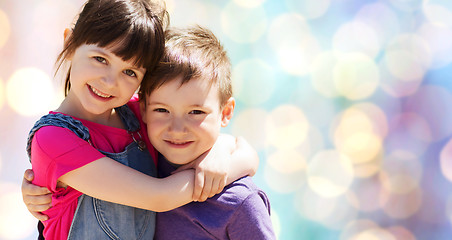 Image showing two happy kids hugging over blue lights background