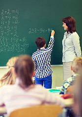 Image showing teacher and schoolboy writing on chalk board