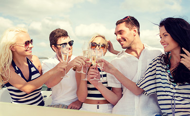 Image showing smiling friends with glasses of champagne on yacht