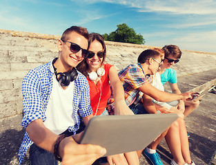 Image showing group of smiling friends with tablet pc outdoors