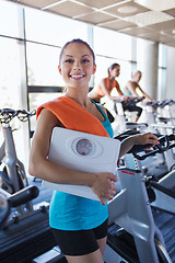 Image showing smiling woman with scales and towel in gym