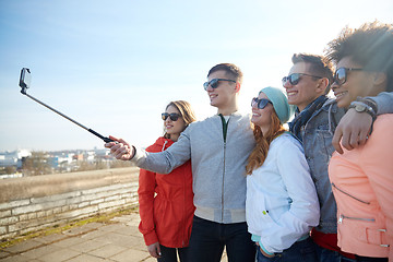 Image showing smiling friends taking selfie with smartphone