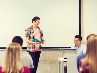 Image showing group of smiling students and teacher in classroom