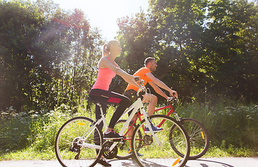 Image showing happy couple riding bicycle outdoors