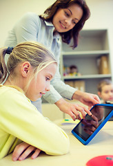 Image showing little girl with teacher and tablet pc at school