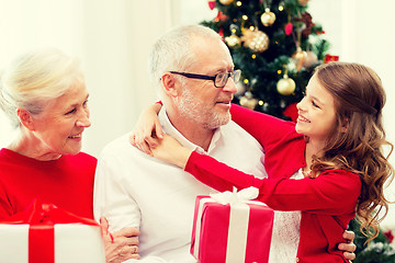 Image showing smiling family with gifts at home