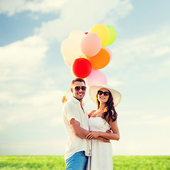 Image showing smiling couple with air balloons outdoors