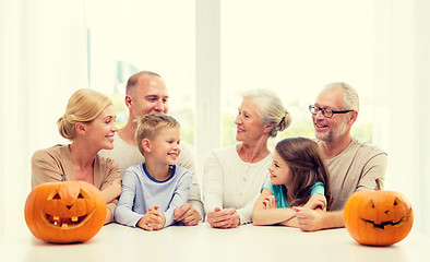 Image showing happy family sitting with pumpkins at home