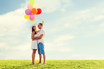 Image showing smiling couple with air balloons outdoors