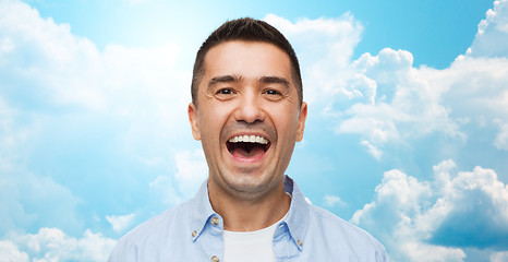 Image showing laughing man over blue sky and clouds background