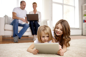 Image showing happy little girls with tablet pc computer at home