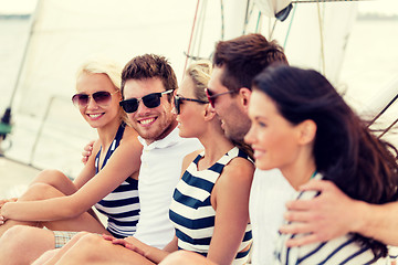 Image showing smiling friends sitting on yacht deck