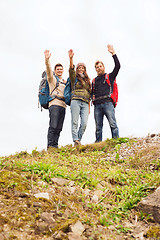 Image showing group of smiling friends with backpacks hiking