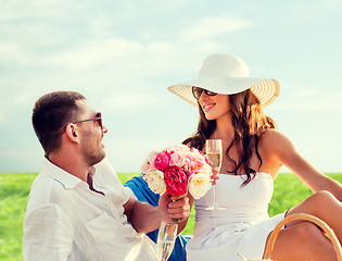 Image showing smiling couple drinking champagne on picnic