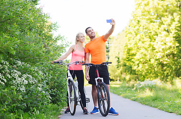 Image showing couple with bicycle taking selfie by smartphone