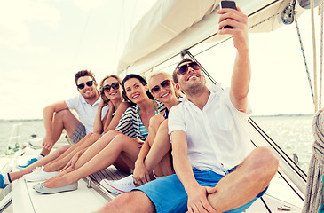 Image showing smiling friends sitting on yacht deck